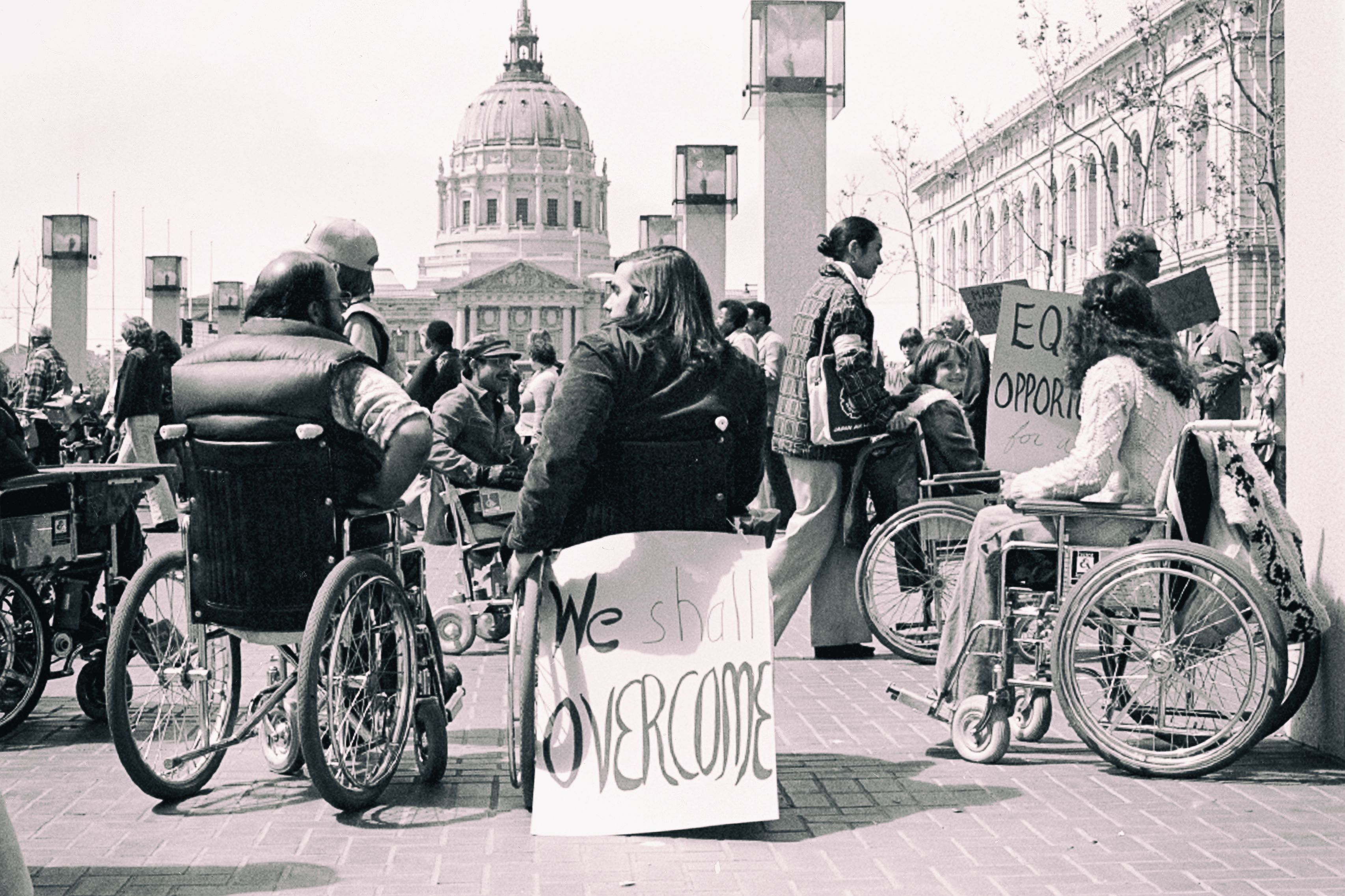 Protestors in wheelchairs with protest signs